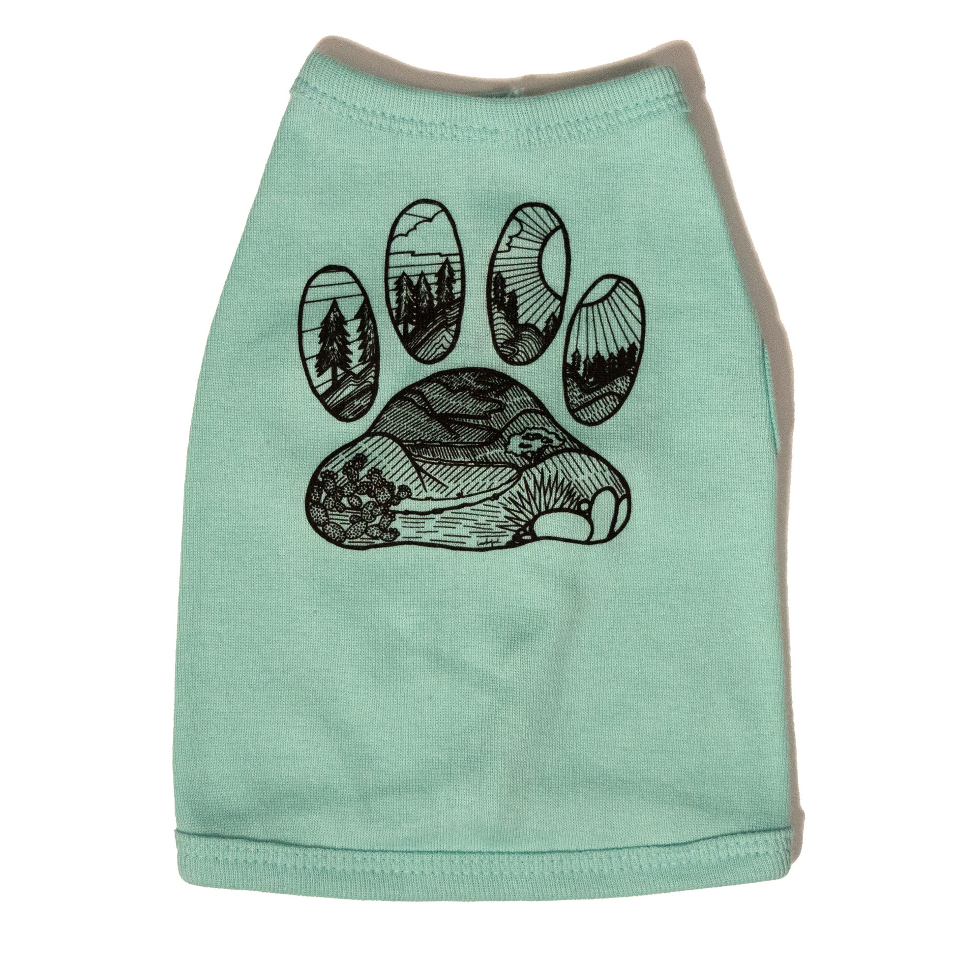A light blue color dog shirt in a tank top style. The illustrated design on the back features a desert floor leading up to mountains with pine trees. The design is inside the shape of a dog paw print. The illustration is in black and the shirt color is light blue.