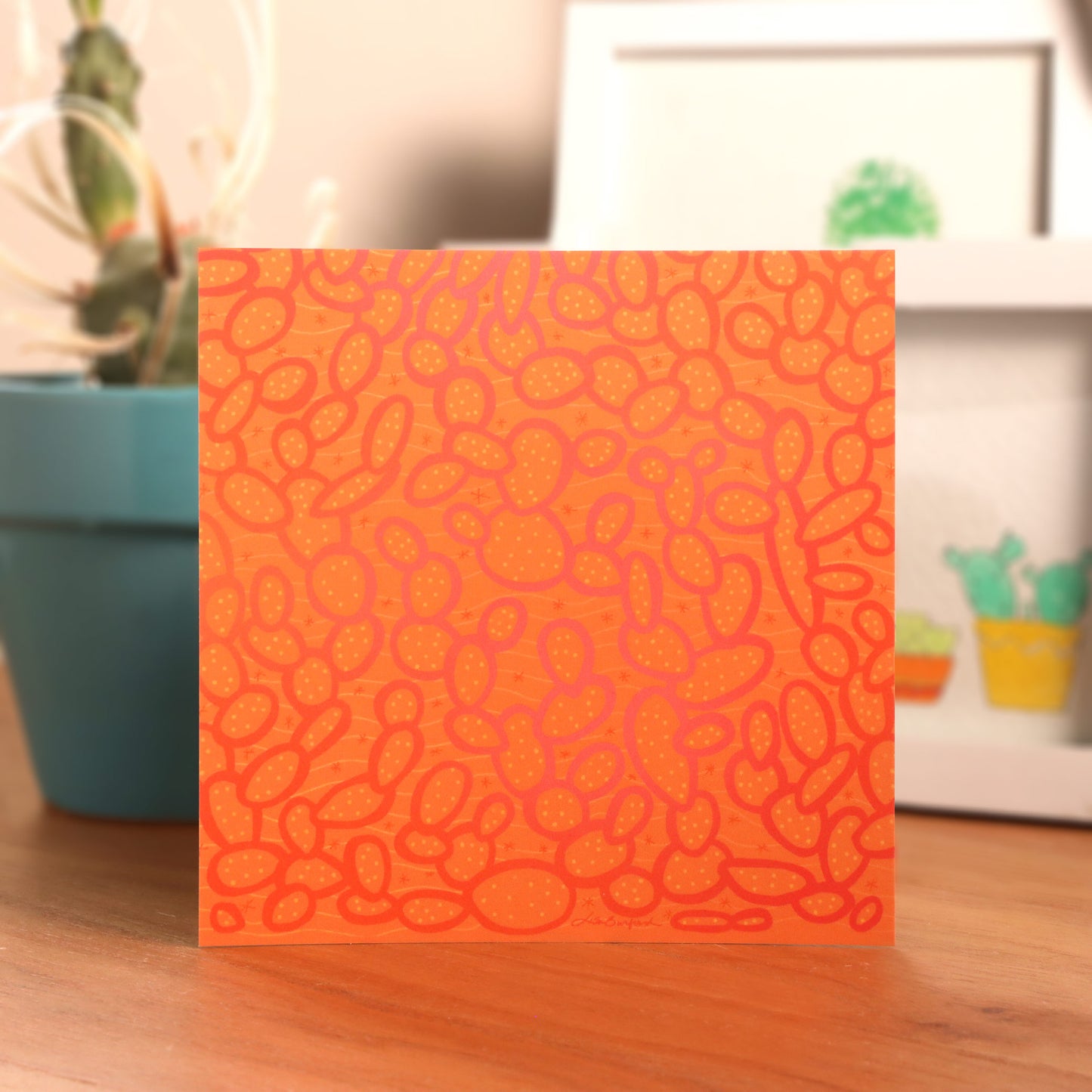 Wild Paddles Print on a table with cactus and framed images in the background