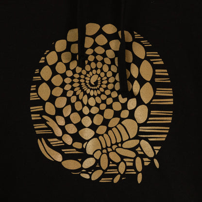 Closeup of the design. A black hoodie sweatshirt with an illustrated design of a metallic gold scorpion with its tail coiled into a spiral.